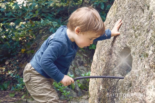 子供が穴の中を覗いている